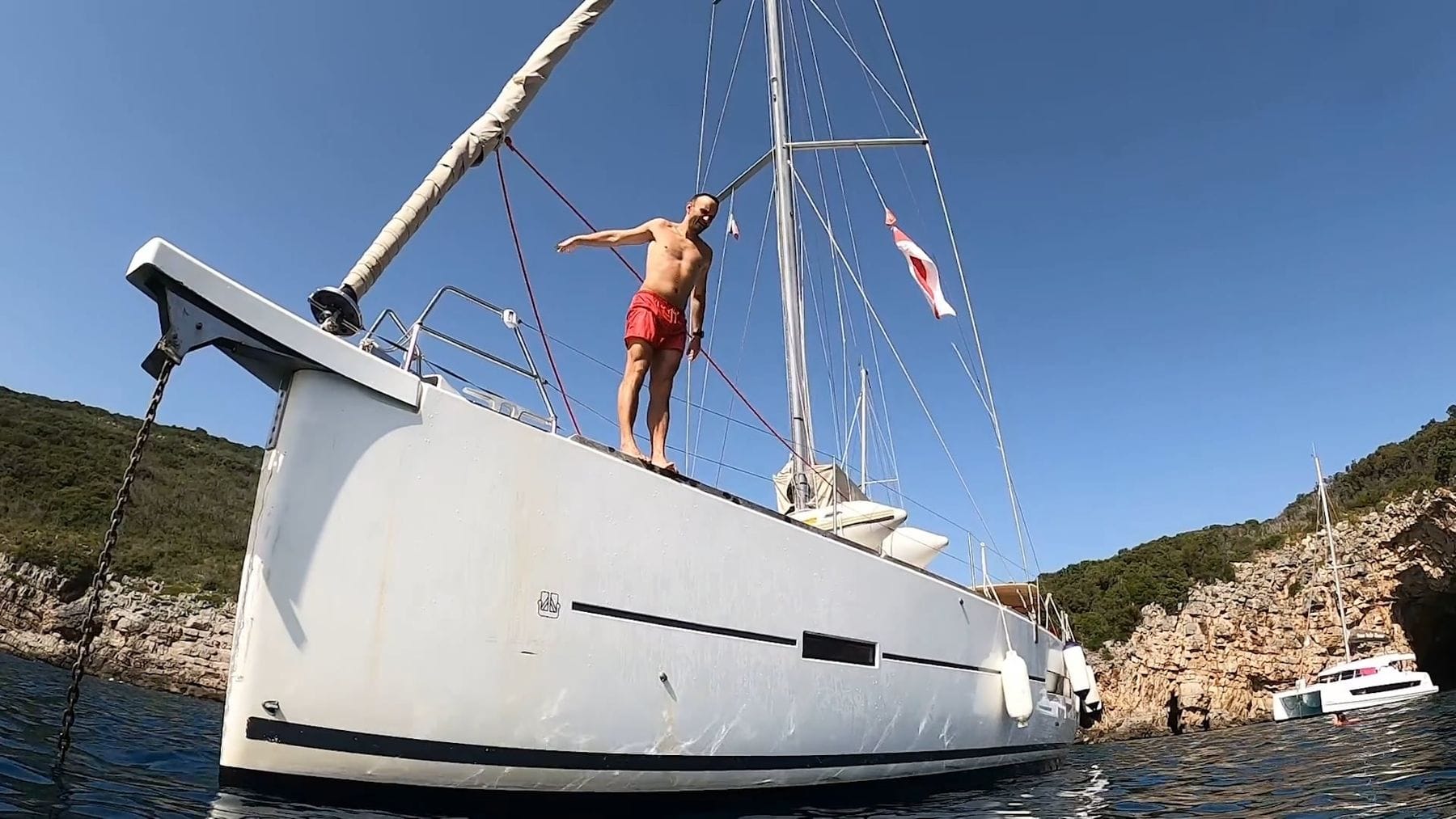Baignade depuis un voilier dans une crique méditerranéenne ensoleillée