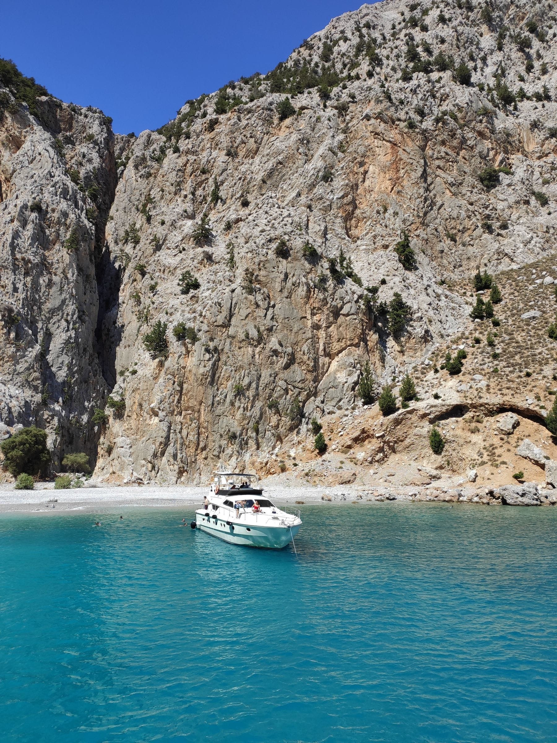 Yacht à moteur dans une crique aux eaux turquoise