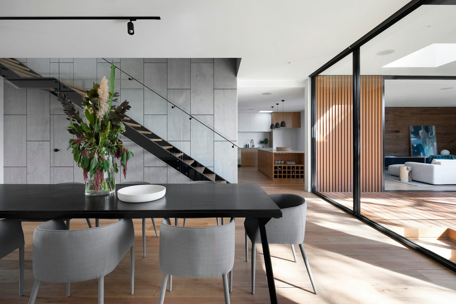 Pièce de vie contemporaine avec matériaux naturels et grandes ouvertures