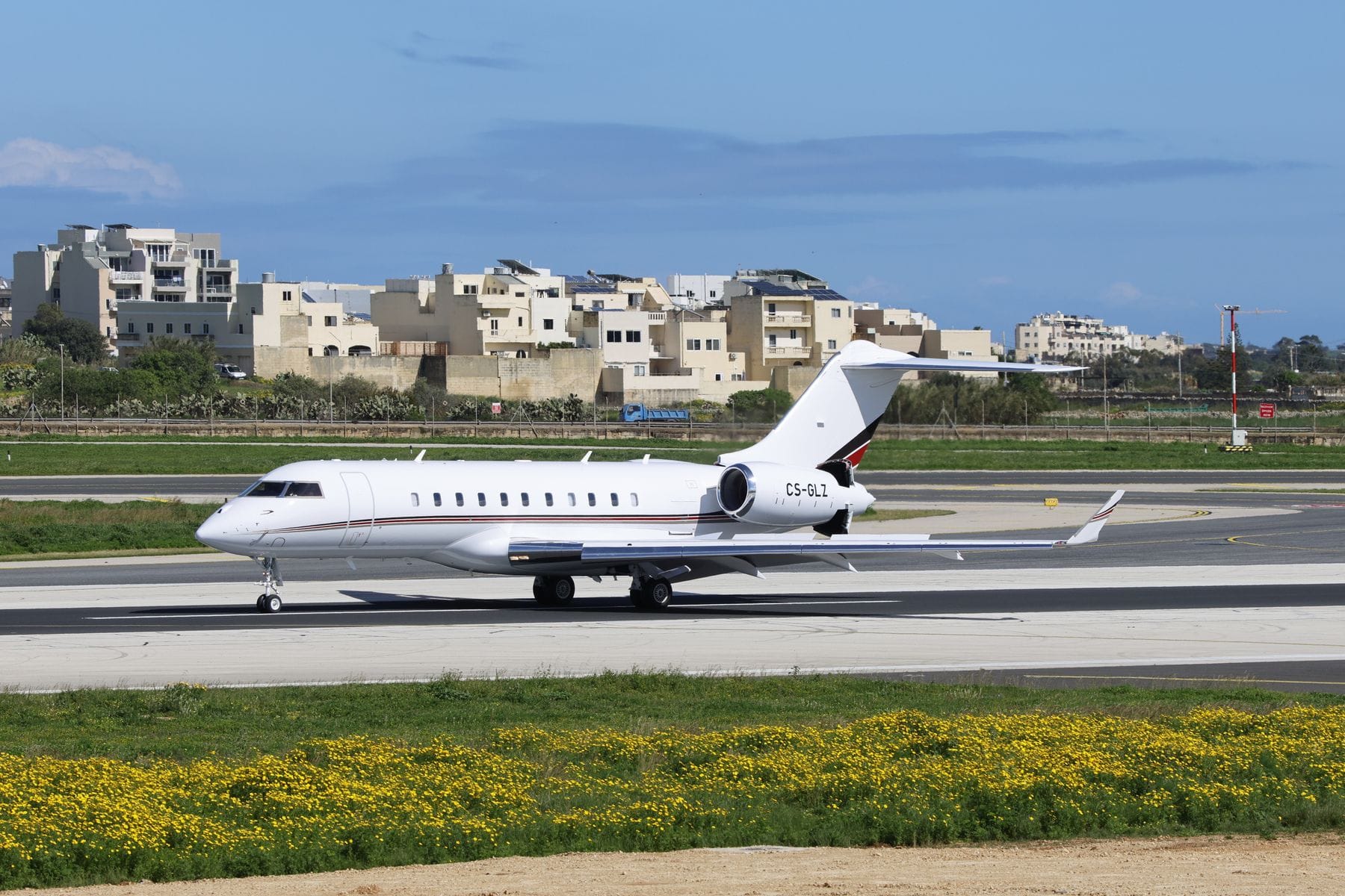 Jet privé blanc au sol sous un ciel bleu
