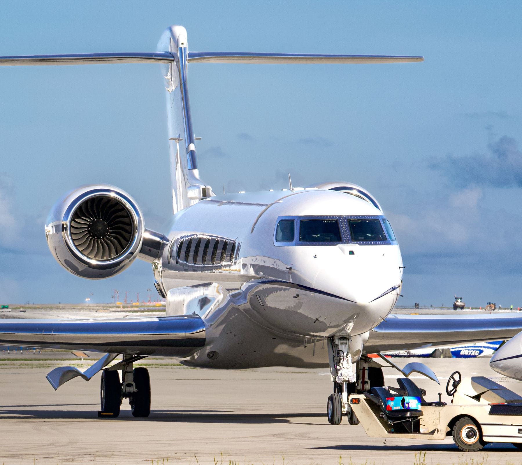 Jet privé blanc au sol sous un ciel bleu